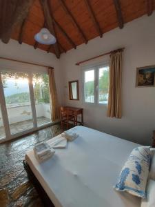 a bedroom with a large bed and two windows at Beautiful house 800m from Koumeika, Samos in Koumeika