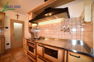 una cucina con piano cottura e forno di Casa Dolomiti - BERTA a Campitello di Fassa