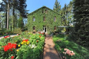 a house covered in ivy with a garden of flowers at Pension Altes Posthaus in Dangast