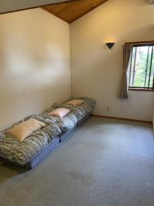 a bedroom with a bed in the corner of a room at Hakuba-ism in Hakuba