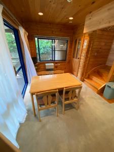 una habitación con mesa y sillas en una cabaña en Hakuba-ism en Hakuba