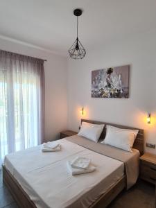 ein Schlafzimmer mit einem großen Bett mit zwei Handtüchern darauf in der Unterkunft Seaside Apartments in Keramotí