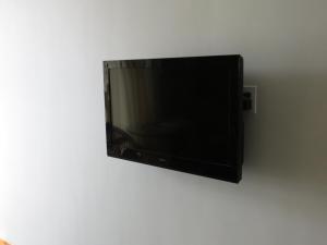 TV de pantalla plana colgada en la pared en Sugarloaf Lodge, en Sugarloaf Shores