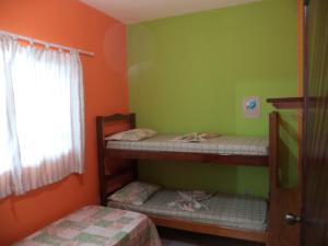 two bunk beds in a room with green and orange walls at Pisco Chalés in Ubatuba