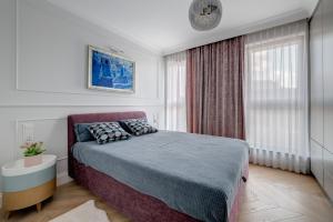 sypialnia z dużym łóżkiem i oknem w obiekcie Unique Apartments - Browar Gdański w Gdańsku