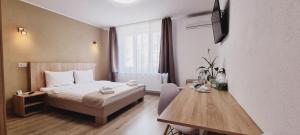 a hotel room with a bed and a wooden table at Lindenhaus in Sibiu
