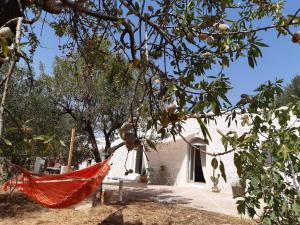 una hamaca naranja colgada de un árbol frente a una casa en Casa Baronessa, en Ceglie Messapica