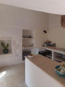 cocina con paredes blancas y encimera blanca en Casa Baronessa, en Ceglie Messapica