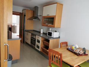 cocina con mesa de madera y microondas en Estancia vacacional nogareda para 6 personas, en Bueu