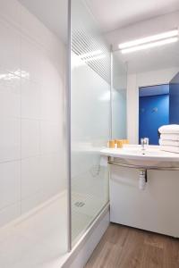 a white bathroom with a shower and a sink at ibis budget Bayonne in Bayonne