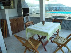 a table and chairs on a patio with a pool at Pisco Chalés in Ubatuba