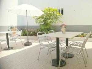 ヴィラ・ノーヴァ・デ・セルヴェイラにあるCerqueira's Houseのパティオにテーブルと椅子と傘
