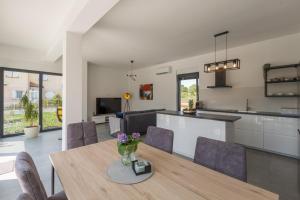 Una cocina y un comedor con mesa y sillas. en Villa Luna Fiorini by SeeAdria, en Brtonigla