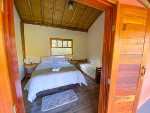 a bedroom with a bed and a window and a door at POUSADA ESTÂNCIA DAS CACHOEIRAS in Cunha
