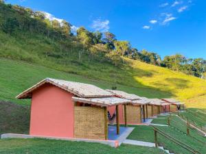 a row of small buildings in front of a hill at POUSADA ESTÂNCIA DAS CACHOEIRAS in Cunha
