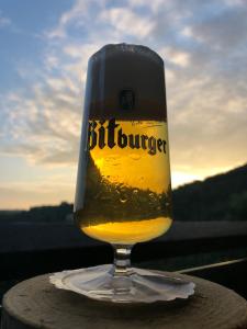 a glass of beer sitting on top of a table at Hotel Berghof in Biersdorf am See