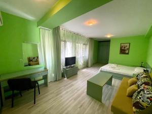 a green bedroom with a bed and a tv at Villa Jackie in Golden Sands