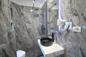 a bathroom with a shower and a toilet and a sink at Portafortuna Apartments in Sarandë
