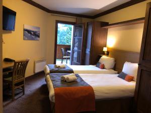 a hotel room with two beds and a window at Appartement montagne spacieux, piscine, SPA à ARC 1950 in Arc 1950