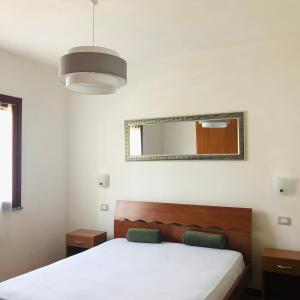 1 dormitorio con cama y espejo en la pared en Stunning apartment in beautiful Villa Florence, 150 mt from the beach, gated 5 mt from the sea, en Solanas