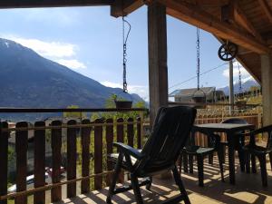 een veranda met stoelen en een tafel en bergen bij Le Ruote in Berbenno di Valtellina