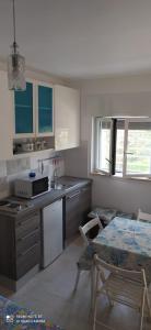 a kitchen with a sink and a table and a microwave at Villa Francesca Appartamento Meraviglioso in Polignano a Mare