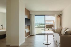 Una sala de estar con un sofá, una cama y una mesa. en Meliá Palma Marina, en Palma de Mallorca