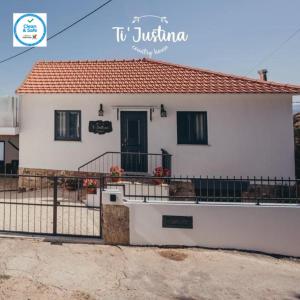 a white house with a fence in front of it at Ti`Justina Country House in Rossas