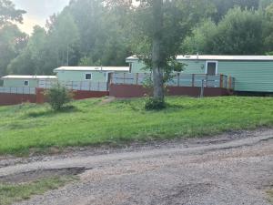 a field with two mobile homes and a tree at Pension Peklo in Trutnov