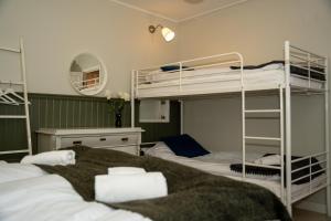 a room with three bunk beds and a mirror at Svabesholms Kungsgårds B&B och Pensionat Stenshuvud in Kivik