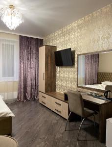 um quarto com uma secretária, um espelho e uma cama em отель VICTORIA CITY em Achinsk