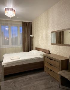 um quarto com uma cama, uma cómoda e um espelho em отель VICTORIA CITY em Achinsk
