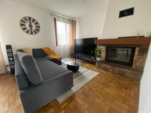 uma sala de estar com um sofá e uma lareira em Maison chaleureuse avec un grand jardin em La Bonneville
