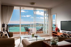 a living room with a view of the water at The Sebel Quay West Auckland in Auckland