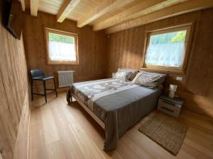 a bedroom with a bed in a wooden cabin at Chalet Camporosso Rosenstein in Camporosso in Valcanale