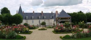 a large house with a garden of flowers and a gazebo at Le Château d'Hauterives in Argentré