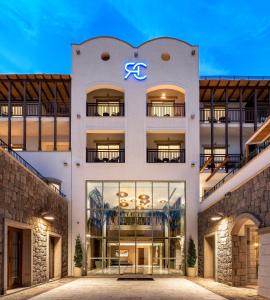 an exterior view of a white building with a sign on it at Radisson Collection Hotel, Bodrum in Akyarlar