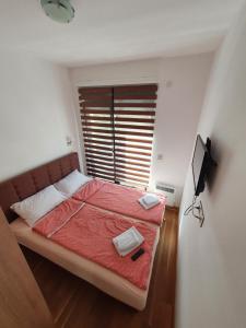 a bedroom with a bed with red sheets and a window at Apartman Green Lux - Balkan Hil 1 in Zlatibor