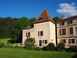 ein altes Steingebäude mit einem Turm auf einem Feld in der Unterkunft La Bastide Portoly Gîte "Le Pigeonnier" in Penne-dʼAgenais