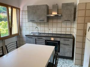 a kitchen with a stove and a sink and a table at Mati's House in Bellagio