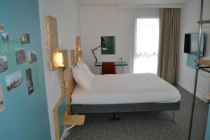 a bedroom with a white bed and a lamp at greet Hotel Rennes Pace in Pacé