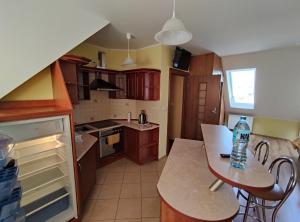 a kitchen with a table with a bottle of water on it at Apartament Pod Lasem in Police +14 photos