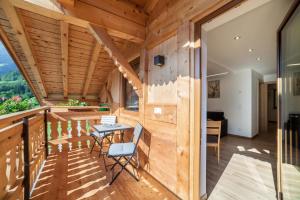 a room with wooden walls and a table on a balcony at Innergasserhof Ferienwohnung Edelweiss in San Martino