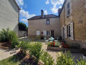 um pátio de uma casa com cadeiras e flores em COTE VACANCES em Chaumont