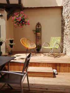 2 Stühle und ein Tisch auf einer Holzterrasse in der Unterkunft Gîte Le Patio in Kaysersberg