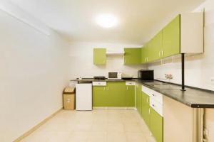 a kitchen with green cabinets and white appliances at AZURE appartment in Keszthely
