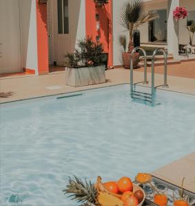 una piscina d'acqua con un cesto di frutta di Casa Morgados - Grândola Guesthouse a Grândola