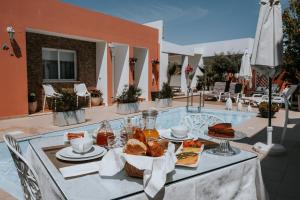 una mesa con comida junto a una piscina en Casa Morgados - Grândola Guesthouse en Grândola
