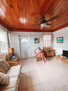 a woman sitting in a chair in a living room with a ceiling at Tropical View Villas in Hartswell