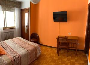 a bedroom with a bed and a table and a television at Hotel España in Lugo